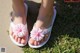 A pair of white flip flops with pink flowers on them.