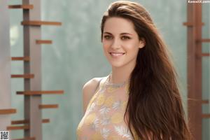 A woman with long brown hair posing for a picture.