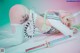 A woman with pink hair laying on the ground with a sword.