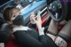 A woman wearing a face mask while sitting in a car.