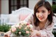 A woman sitting at a table with a bouquet of flowers.